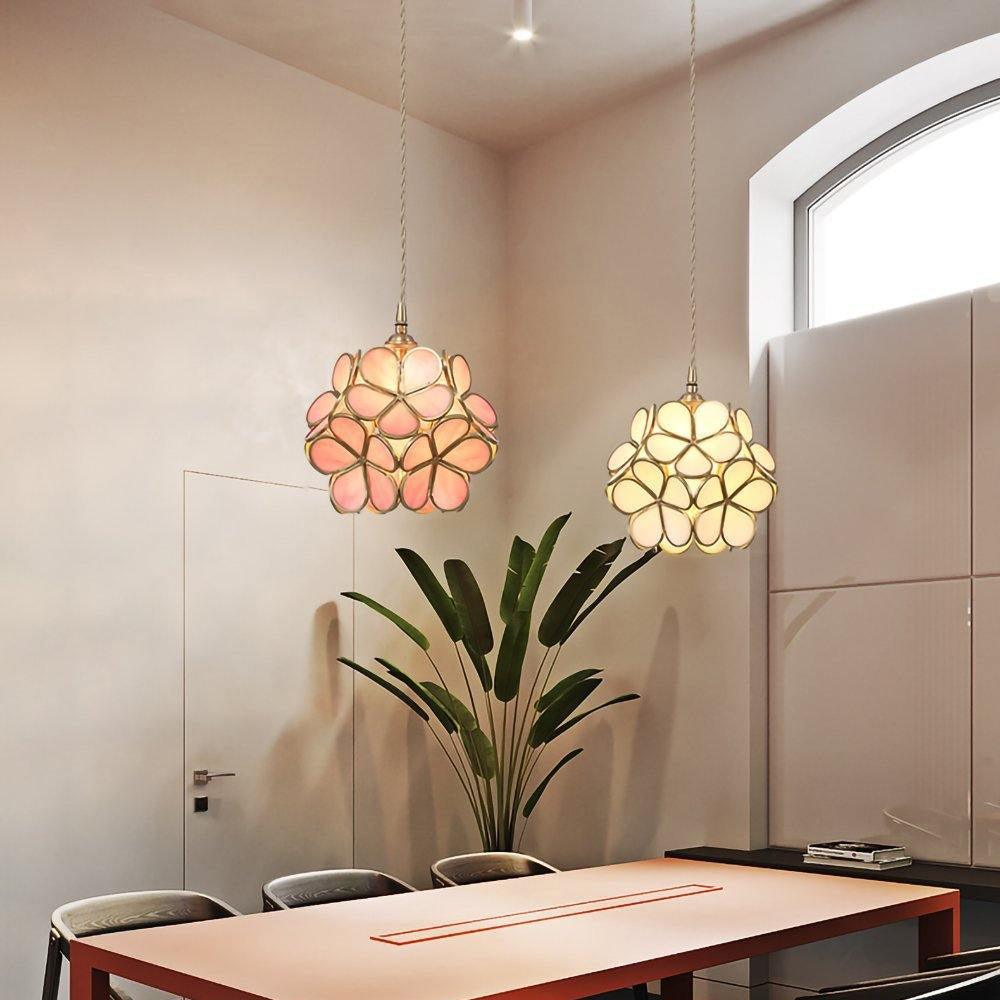 White pendant light and pink pendant light hanging on A table